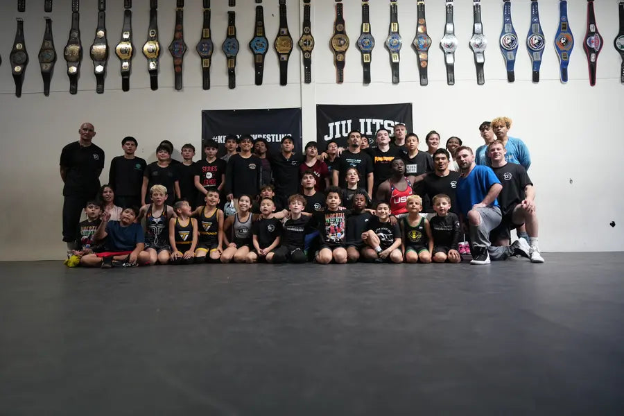 Future Champions Elite athletes and coaches posed together holding championship belts